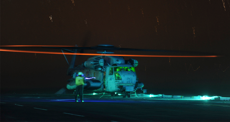 Illustration for article titled An MV-22 Osprey Fills The Night Sky Over The USS Boxer With Psychedelic Slinkies